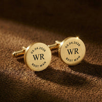 Gold cufflinks with engraved initials and date on a brown textured background