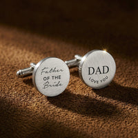 Cufflinks with engraved text on a brown textured background